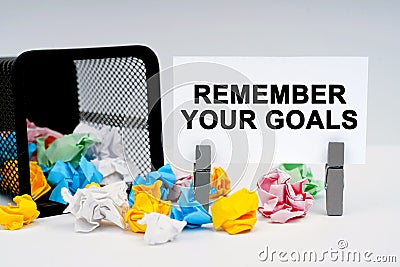 On the table are reporting graphics and a thought plate, inside of which it is written - REMEMBER YOUR GOALS Stock Photo