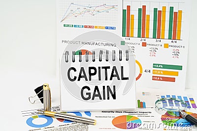 On the table are reports with graphs and a notepad with the inscription - capital gain Stock Photo