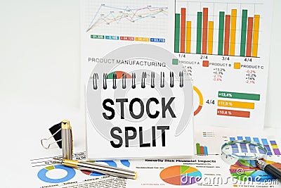 On the table are reports with graphs and a notepad with the inscription - Stock split Stock Photo