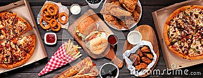 Table scene of assorted take out or delivery foods, top down view on a dark wood banner Stock Photo