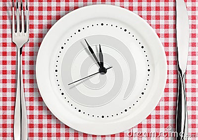 Table setting with blank clock on plate, time concept Stock Photo