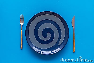 Table setting with plates and flatware on blue background top view Stock Photo