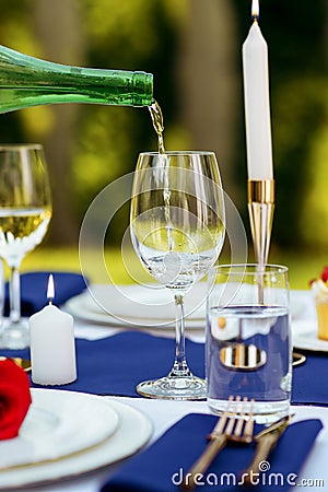 Table setting, wine is poured into a wineglass Stock Photo