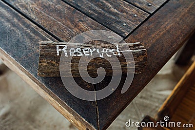 Table with sign reserved on wooden plank. Reservation table in restaurant Stock Photo