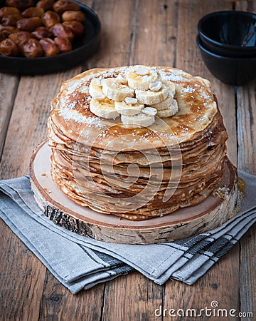 On the table on a stand made of wood cut a pile of thin pancakes Stock Photo