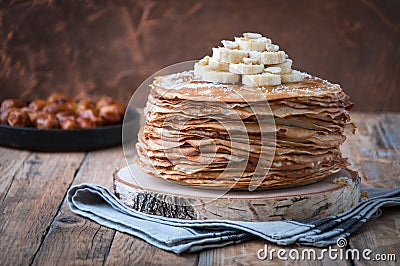 On the table on a stand made of wood cut a pile of thin pancakes Stock Photo