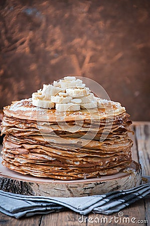 On the table on a stand made of wood cut a pile of thin pancakes Stock Photo