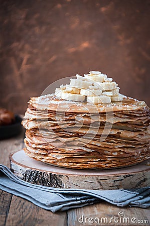 On the table on a stand made of wood cut a pile of thin pancakes Stock Photo