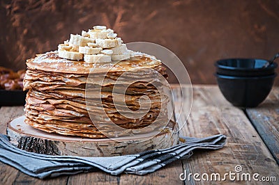 On the table on a stand made of wood cut a pile of thin pancakes Stock Photo