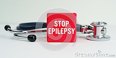 On the table is a stethoscope and a red cube with the inscription - STOP EPILEPSY Stock Photo