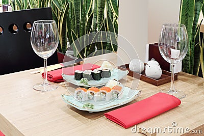 Table with sushi at plates and empty glasses Stock Photo