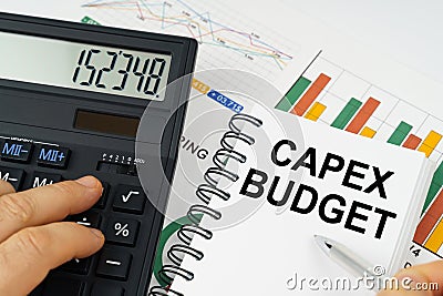 On the table there is a calculator, reports with graphs and a notepad with the inscription - CAPEX BUDGET Stock Photo