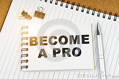 On the table there is a pen, clamps and a notebook with the inscription - BECOME A PRO Stock Photo