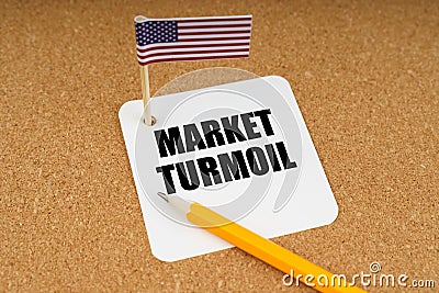 On the table is the US flag, a pencil and a sheet of paper with the inscription - market turmoil Stock Photo