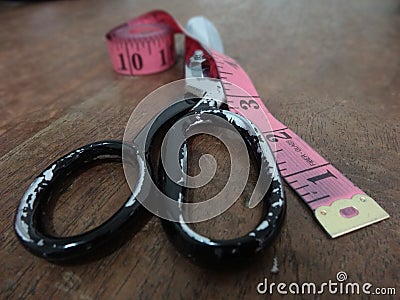 Used scissor on a work table with metric tape lateral closeup Stock Photo