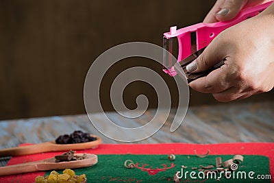 Table with wooden spoons with chocolate and raisin, hands slicing the chocolate Stock Photo