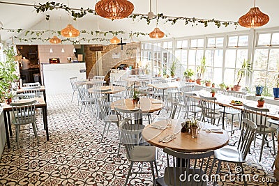 Tables and chairs in an empty restaurant in bright daylight Stock Photo