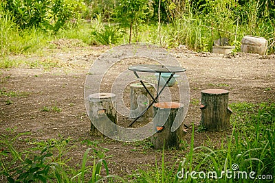 Tables and chairs are made of timber under the big tree Stock Photo