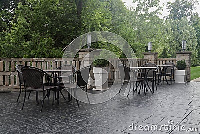 Tables and chairs on patio in morning light Stock Photo