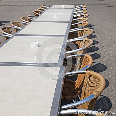 Tables and row of chairs and ashtrays Stock Photo