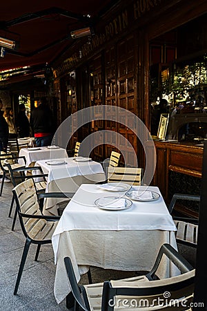 Tables with white tablecloths outside the restaurant Botin in Madrid, Spain Editorial Stock Photo