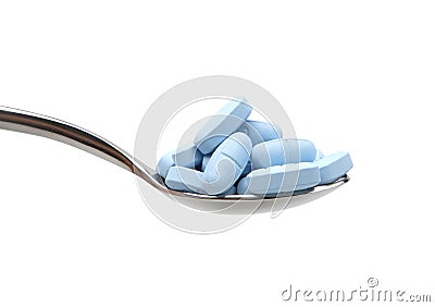 Tablespoon filled with blue pills Stock Photo