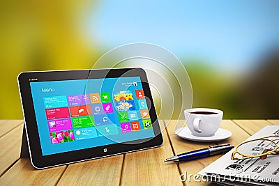 Tablet computer with business objects on wooden table outdoors Stock Photo