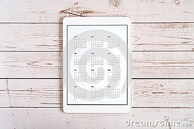 Tablet computer with an open app of calendar for unspecified unknown date year without date on a wooden boards background. concept Stock Photo