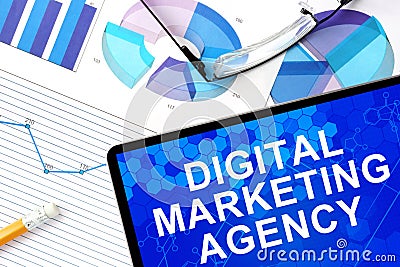 Tablet with digital marketing agency, graphs and glasses. Stock Photo