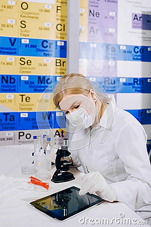 The tablet helps her to work smarter. A female student chemist, Stock Photo