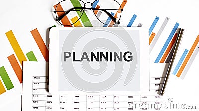 The tablet with text PLANNING on the business charts and pen Stock Photo