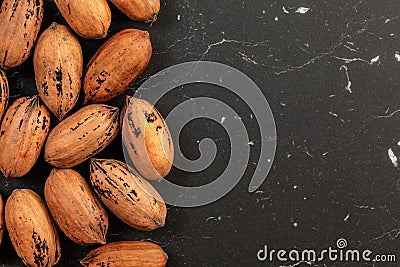 Tabletop photo - whole pecan nuts on black marble like board, space for text right side Stock Photo