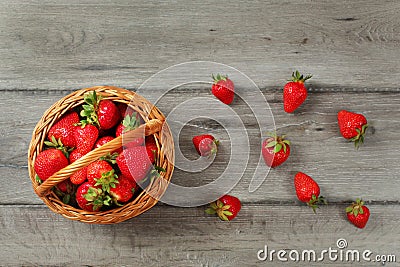 Tabletop view basket with strawberries, some of them spilled on Stock Photo
