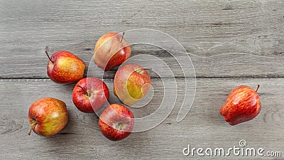 Tabletop view, 7 red glossy apples on gray wooden desk. Stock Photo