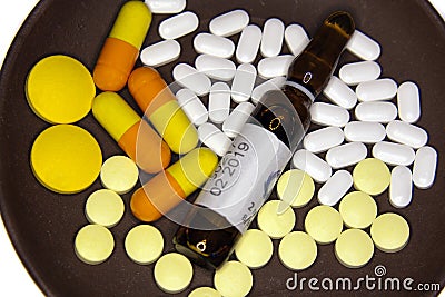 Tablets, capsules and ampoules with medicine on a plate Stock Photo