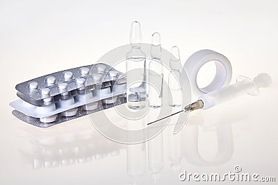 Tablets, medical ampoules and syringe injection on mirror background Stock Photo