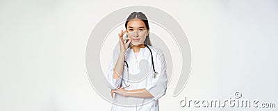 Taboo, medical confidentiality concept. Young asian doctor, female physician showing mouth silence, taboo or zip gesture Stock Photo
