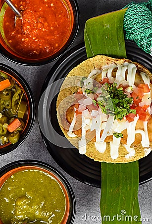 Taco condesa with fried fish on black plate with mexican sauces Stock Photo