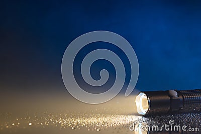 Tactical waterproof flashlight with water drops and fog Stock Photo