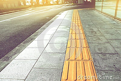 Tactile paving for blind handicap on tiles pathway. Stock Photo