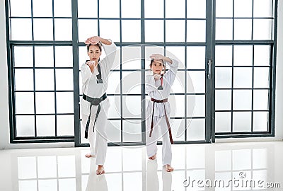 Taekwondo teacher and student show action of different postures in the room with glass windows Stock Photo