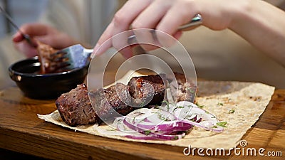 Tagliare le mani di una donna con coltello e forchetta tagliando carne in un piatto sul tavolo in un ristorante stock footage Tagliare le mani di una donna con coltello e forchetta tagliando carne in un piatto sul tavolo in un ristorante stock footage