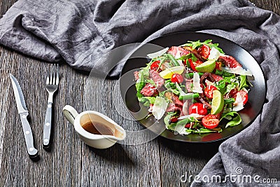 Tagliata sirloin steak salad on a black plate Stock Photo