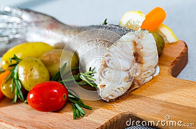 Tail of hake by rustically frying and served with boiled potatoes and tomatoes Stock Photo