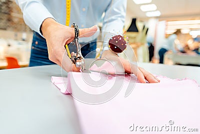 Tailor cutting fabric with scissors Stock Photo