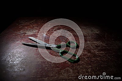 Tailor`s scissors on wooden table in low light. Artwork decoration with toned foggy backlight Stock Photo