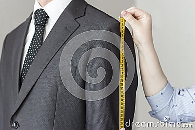 The tailor takes measurements from suit, white background, isolated Stock Photo