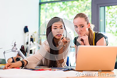 Tailor women or fashion designers work on draft at notebook Stock Photo