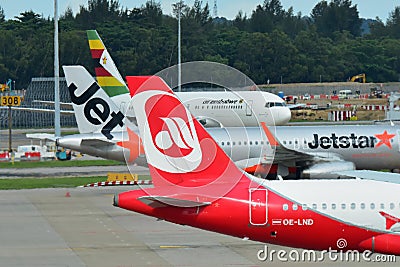 Tails of Air Zimbabwe Boeing 767, Jetstar Asia Airbus A320 and Air Belin Airbus A320 at Changi Airport Editorial Stock Photo