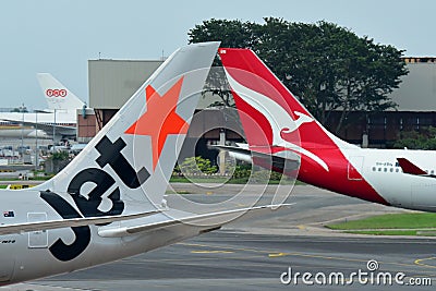 Tails of Jetstar International and Qantas aircraft belonging to the same family at Changi Airport Editorial Stock Photo